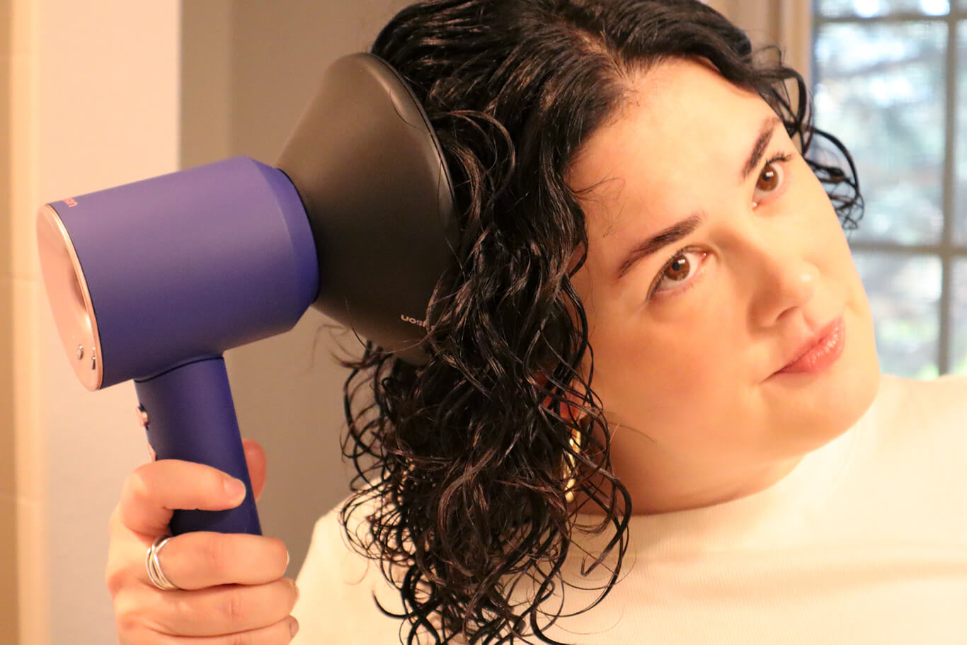 A Woman Uses a Diffuser Hair Dryer to Dry Her Hair