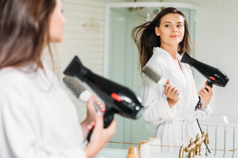 a woman using a hair dryer